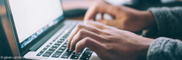 Hände die auf Computertastatur etwas eingeben
