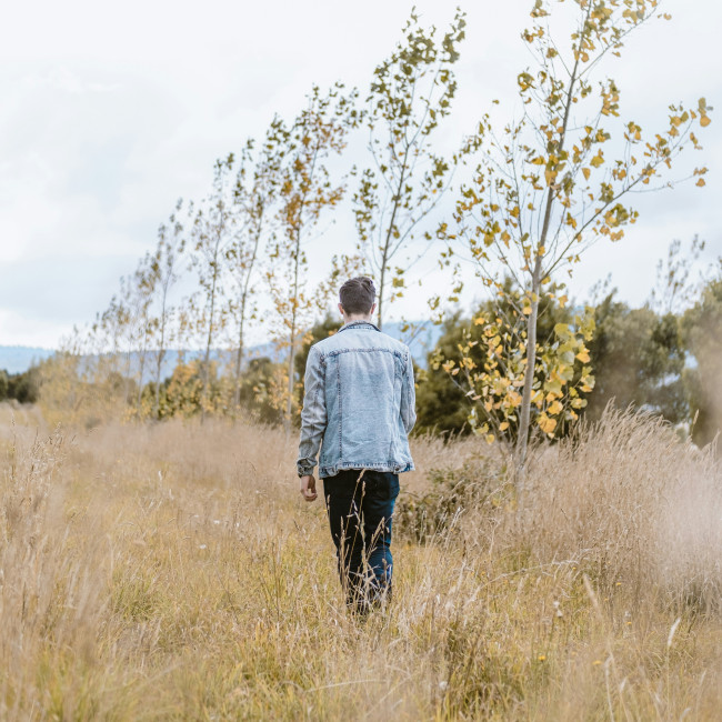 Sie sind nicht alleine – Person steht alleine in Wiese